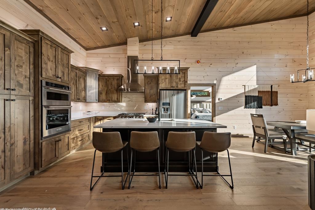 17 Rich Mountain Cherry Log, GA 30522 - Photo 5 of 57 a dining room with stainless steel appliances kitchen island granite countertop a table chairs and a chandelier