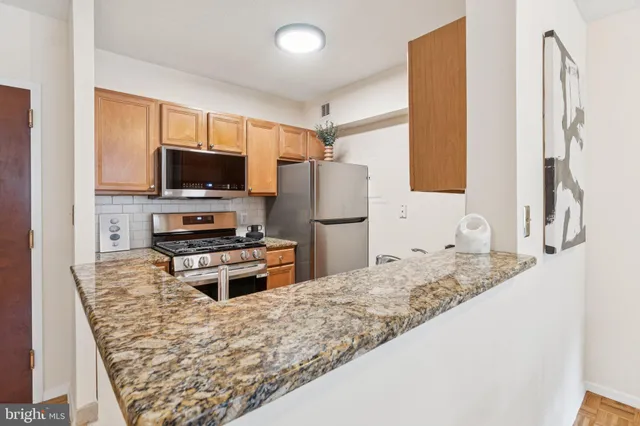 a kitchen with stainless steel appliances granite countertop a refrigerator stove and sink