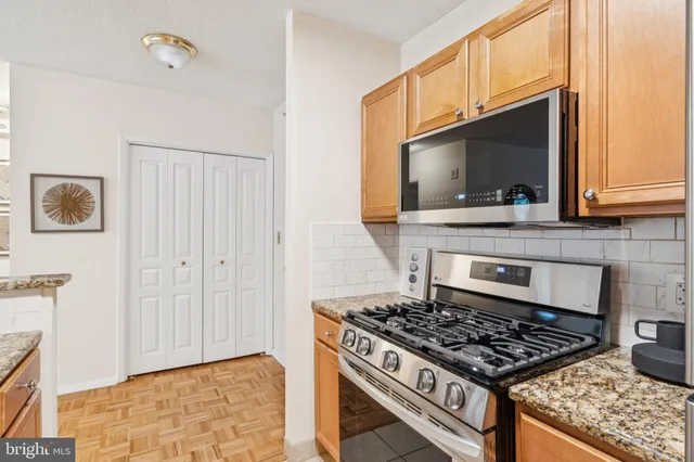 a kitchen with granite countertop a stove and a microwave