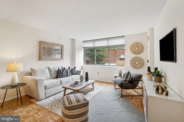 a living room with furniture a flat screen tv and a window