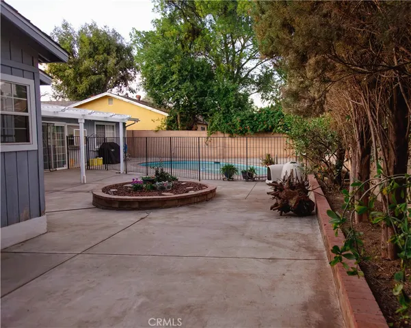 a view of a backyard with table and chairs under an umbrella