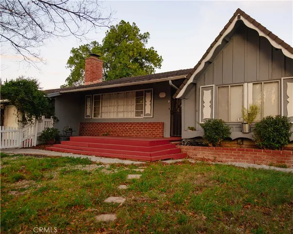 a view of backyard of house with wooden deck and seating space