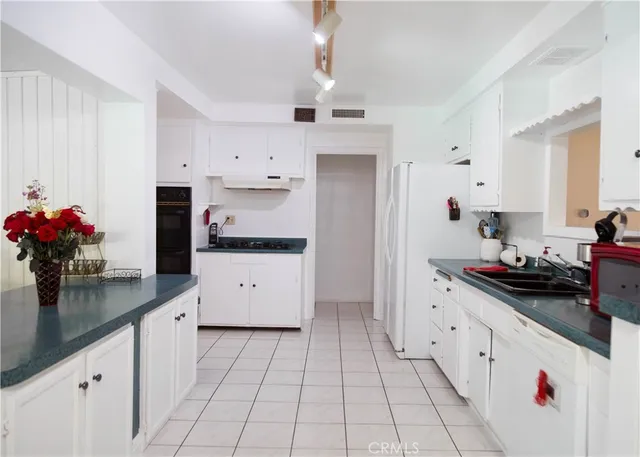 a kitchen with granite countertop a white cabinets and white appliances
