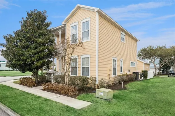 a front view of a house with garden and trees
