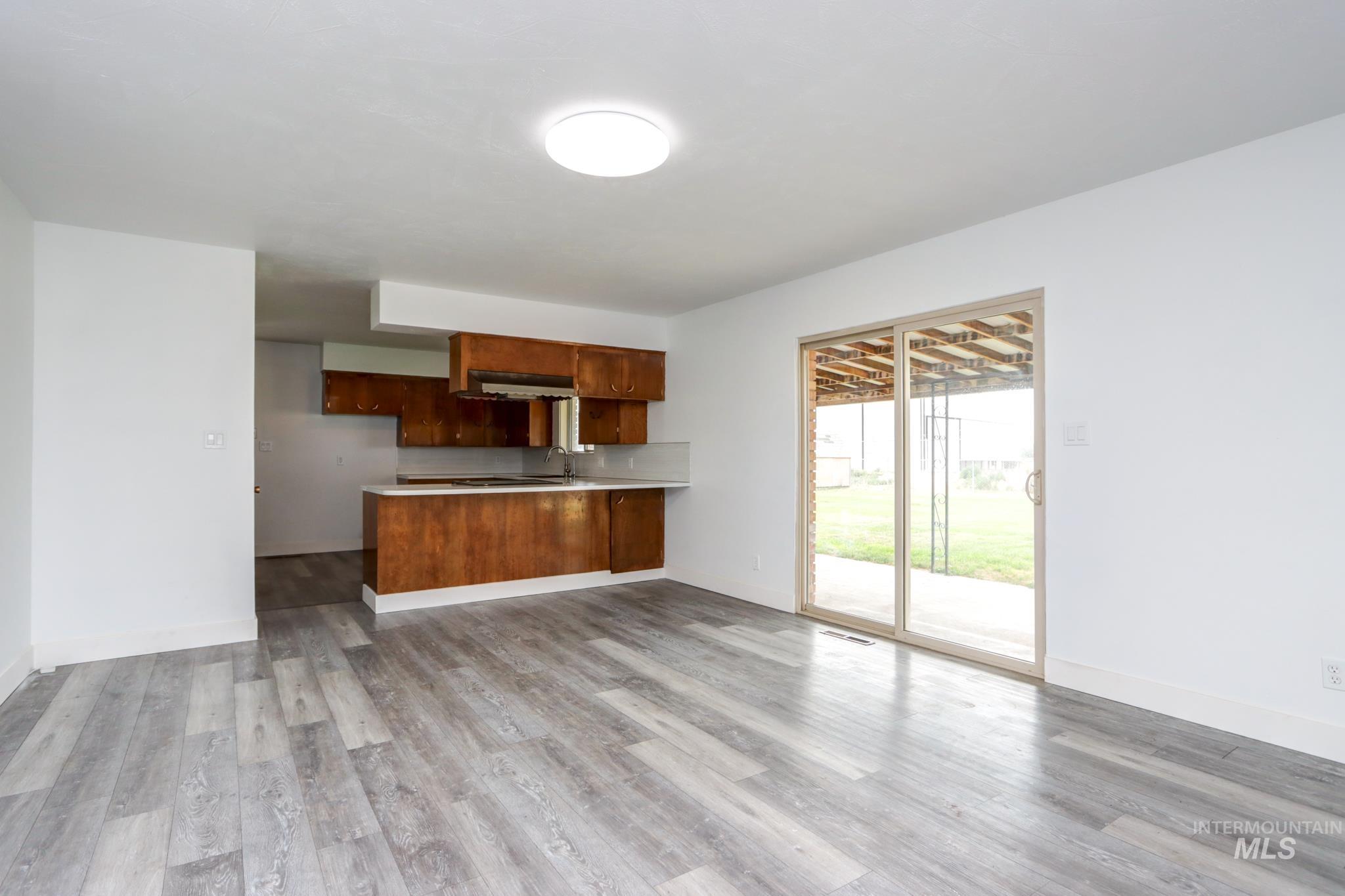 801 Thompson Avenue Nyssa, OR 97913 - Photo 4 of 46 Open-concept living area featuring light wood-finish flooring, white walls, and a contemporary flush-mount ceiling light