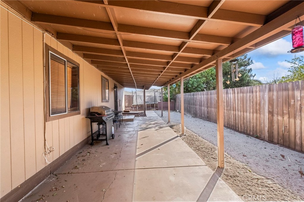 24847 Split Rail Road Wildomar, CA 92595 - Photo 27 of 45 a view of a patio with table and chairs with wooden floor and fence