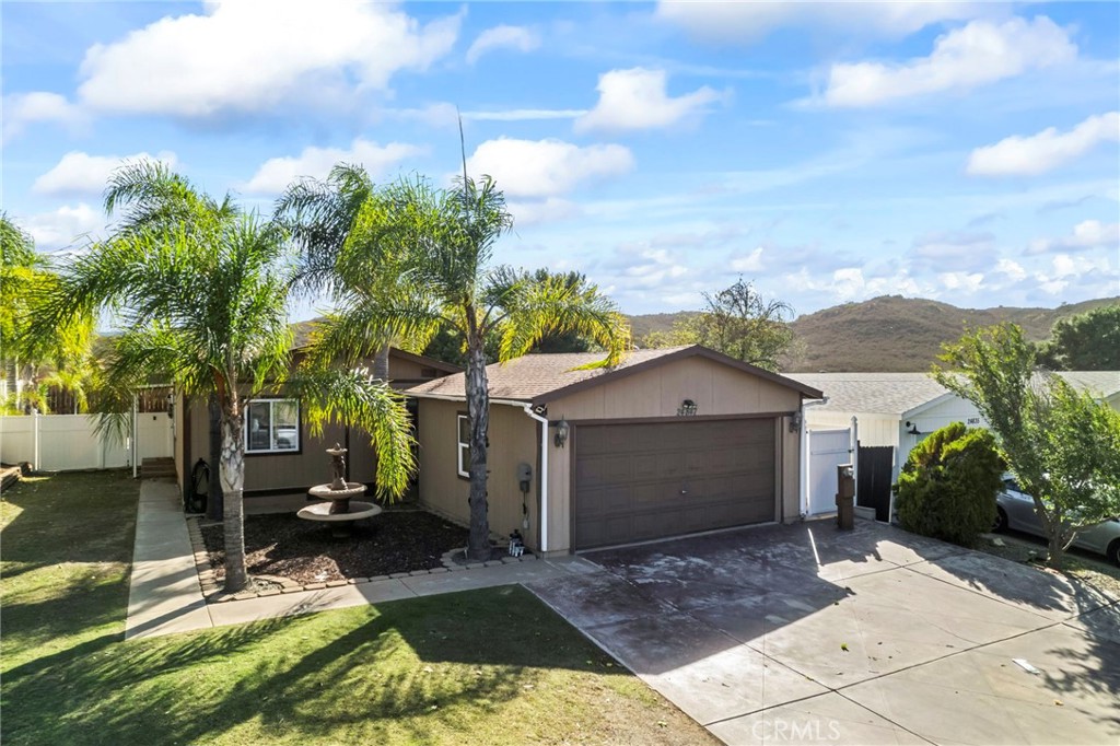 24847 Split Rail Road Wildomar, CA 92595 - Photo 39 of 45 a view of a white house with a yard and potted plants