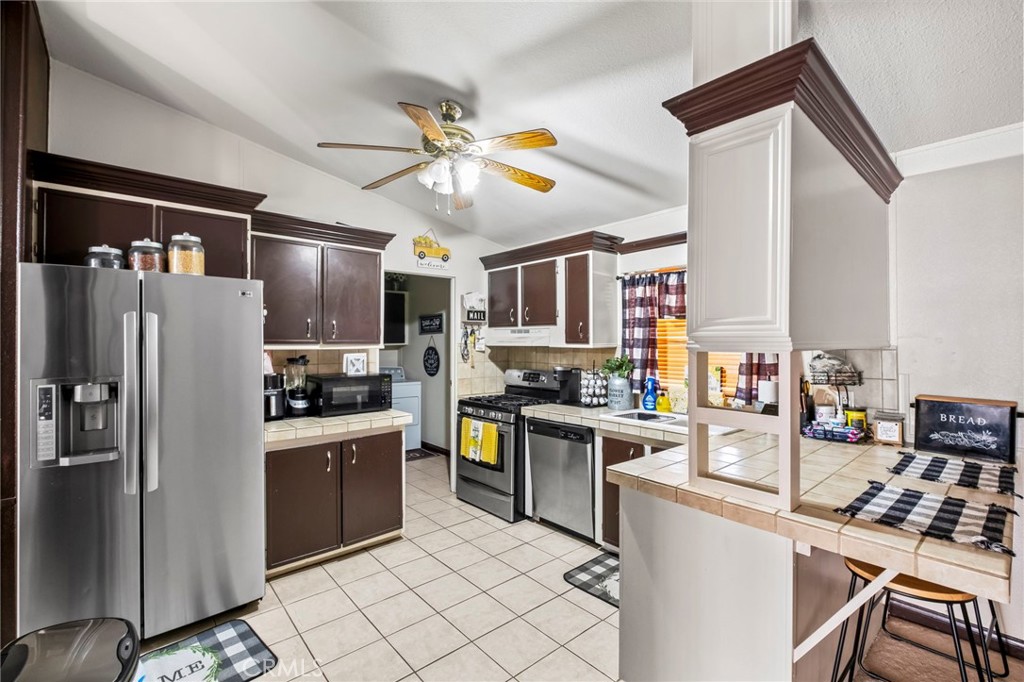 24847 Split Rail Road Wildomar, CA 92595 - Photo 5 of 45 a kitchen with stainless steel appliances granite countertop a refrigerator a stove top oven a sink dishwasher and white cabinets with wooden floor