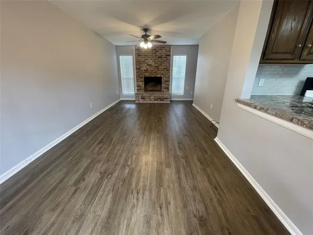 a view of a hallway with wooden floor and a fireplace