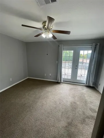 an empty room with chandelier fan