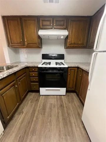a kitchen with a stove and white cabinets