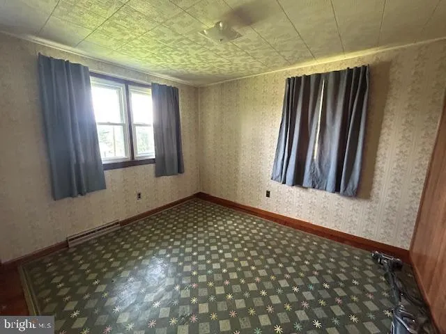 a room with water heater and wooden cabinets