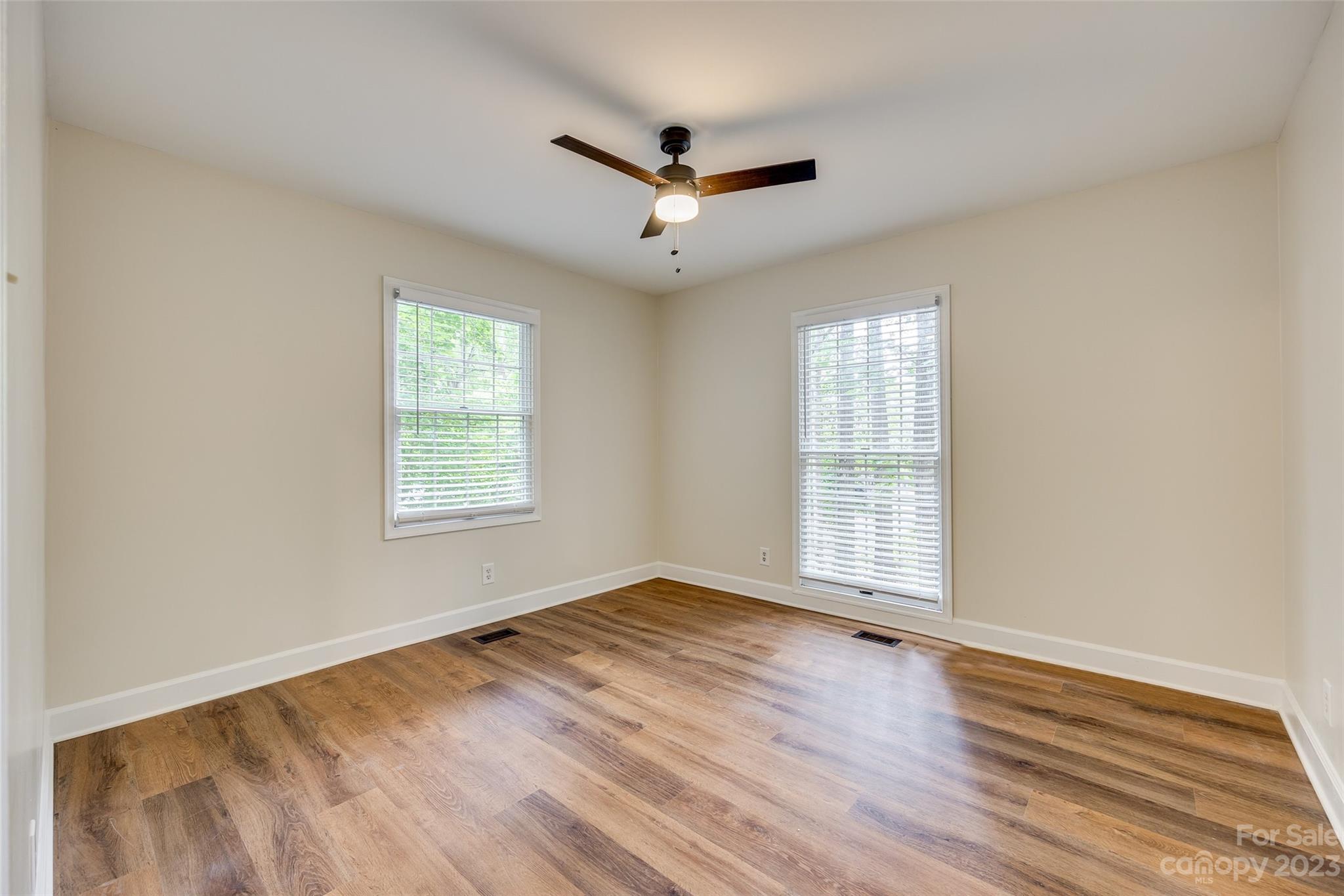 6 Sandy Cove Road Lake Wylie, SC 29710 - Photo 19 of 33 an empty room with wooden floor ceiling fan and windows