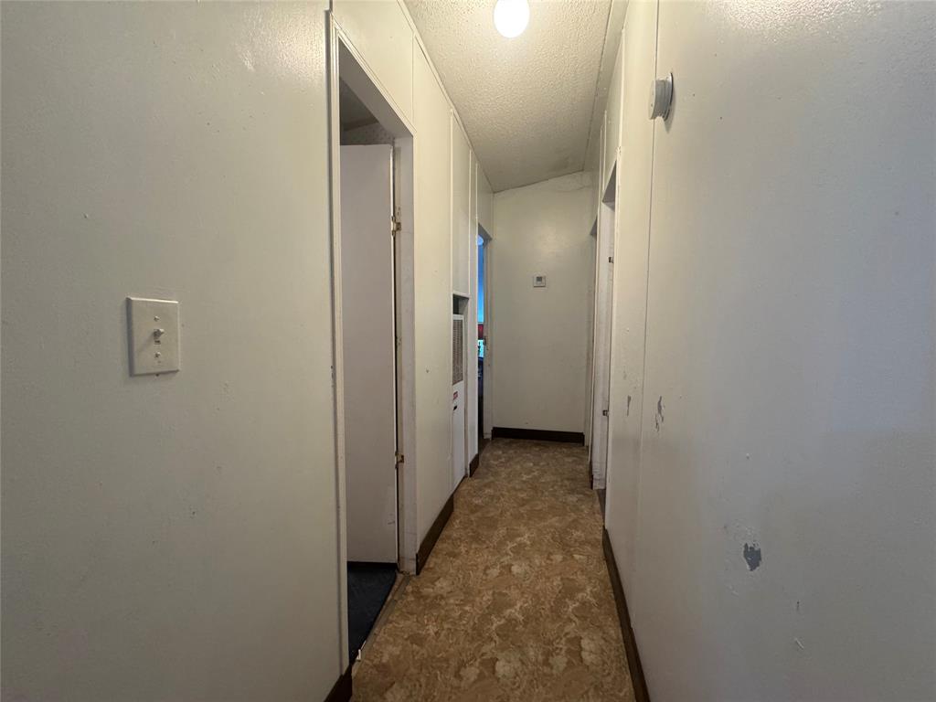 1614 Cole Road Bellmead, TX 76705 - Photo 10 of 21 Corridor featuring paneling walls, a flush-mount ceiling light, and patterned flooring