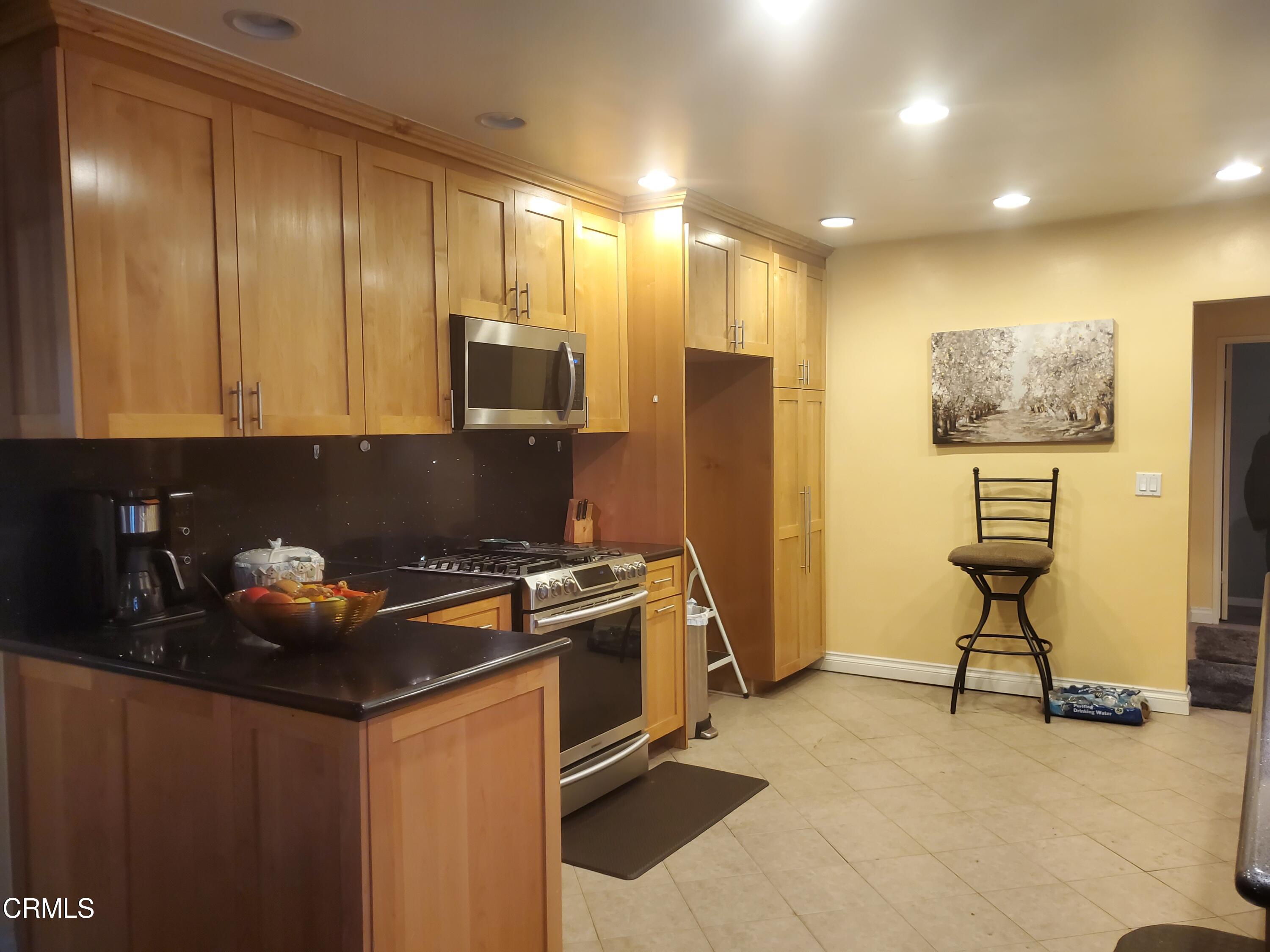 905 Chapman Avenue Pasadena, CA 91103 - Photo 6 of 20 a kitchen with stainless steel appliances granite countertop a stove a refrigerator and a microwave