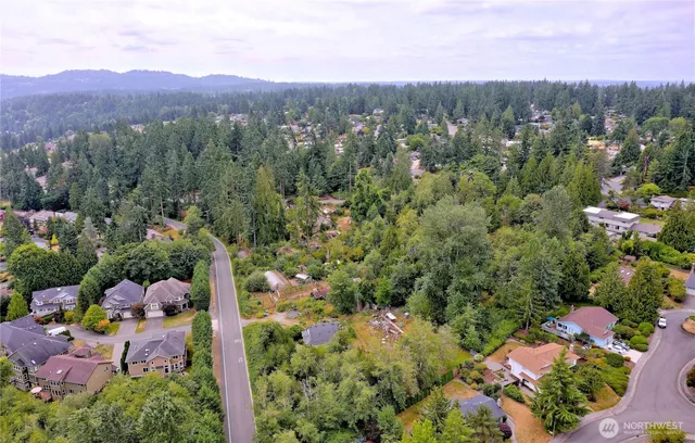 an aerial view of a houses with a yard and mountain