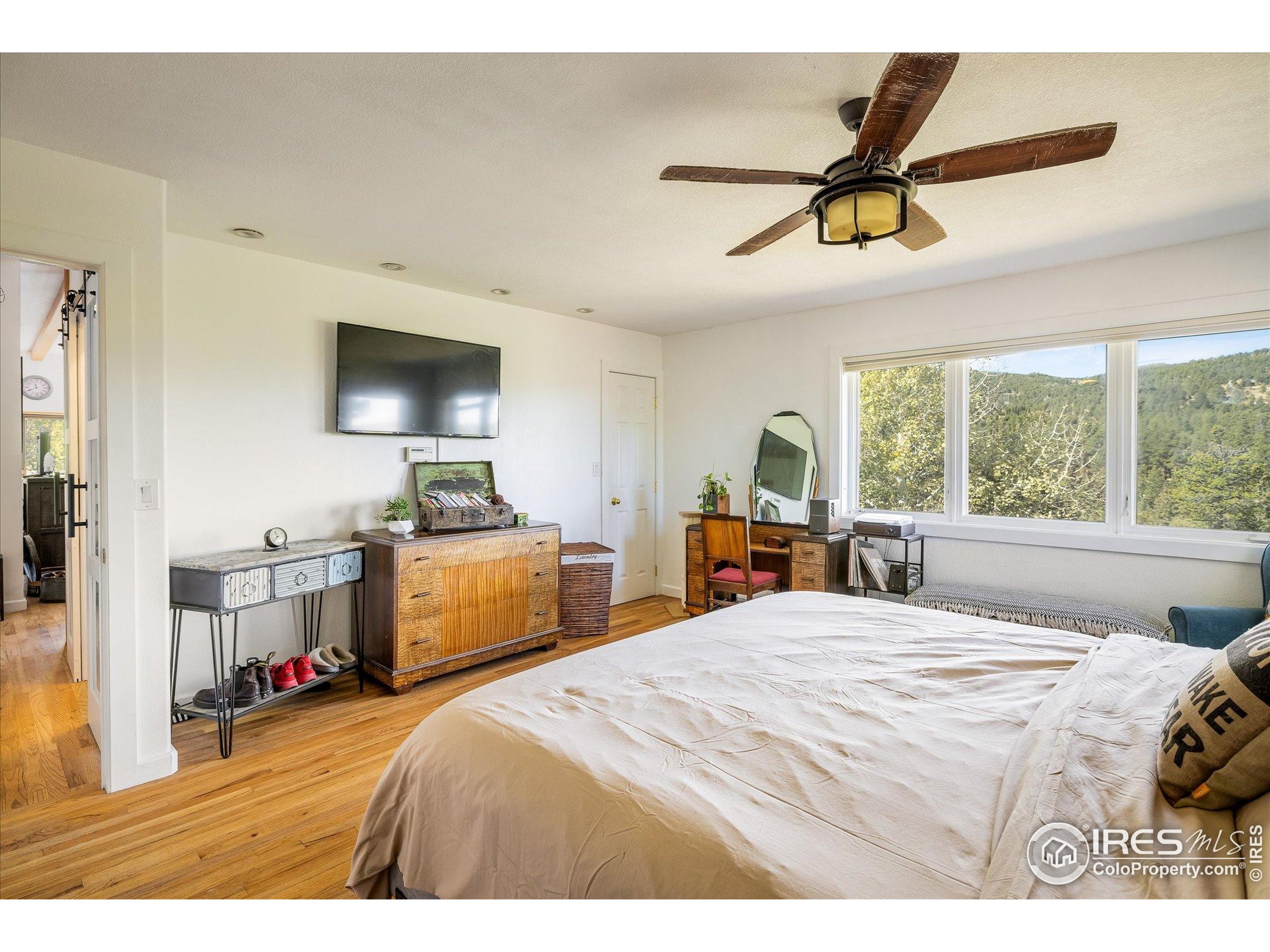 11935 Vonnie Claire Road Golden, CO 80403 - Photo 25 of 42 a bedroom with a bed and a flat screen tv