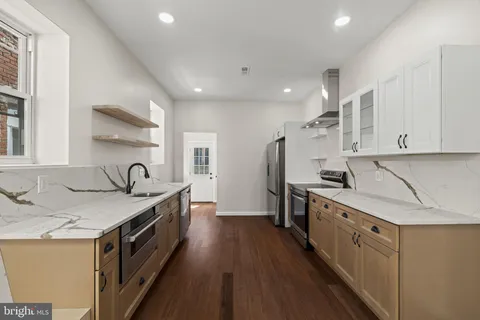 a kitchen with stainless steel appliances granite countertop a sink stove and refrigerator