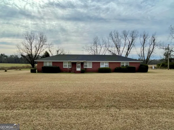 a front view of a house with a yard and trees