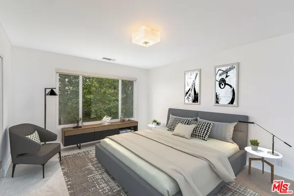 a bedroom with a bed and a large window