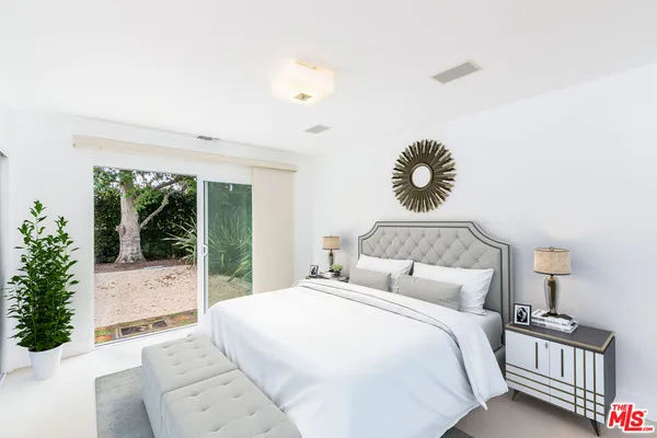 a bedroom with a bed and a large window
