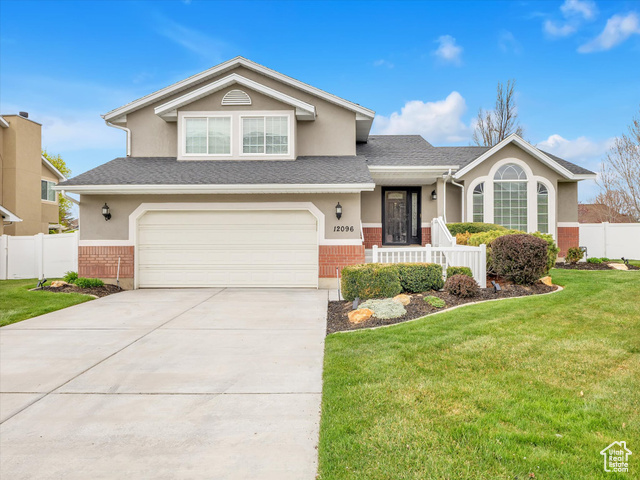 12096 Hidden Valley Road Sandy, UT 84092 - Photo 1 of 1 Tri-level home with stucco siding, a front yard, fence, brick siding, and a garage