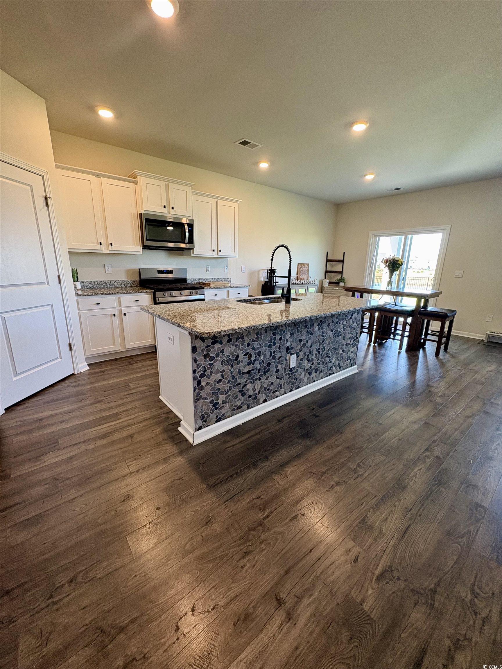 1715 Perthshire Loop Myrtle Beach, SC 29579 - Photo 10 of 39 Kitchen with appliances with stainless steel finishes, light stone countertops, white cabinetry, dark wood-style floors, and recessed lighting