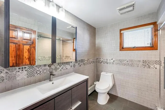 a bathroom with a toilet sink and mirror