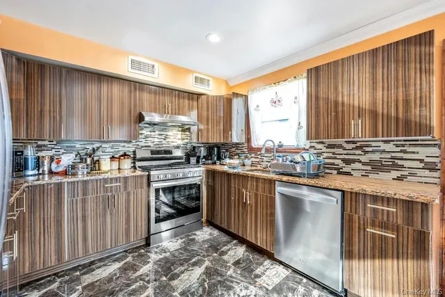 a kitchen with stainless steel appliances granite countertop a refrigerator stove and cabinets