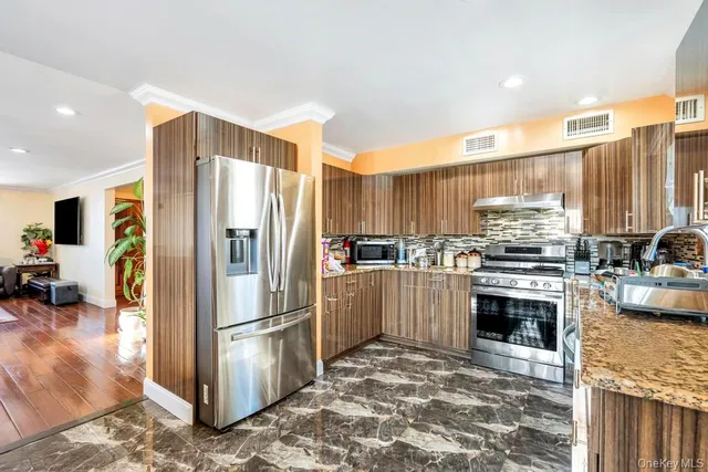 a kitchen with stainless steel appliances granite countertop wooden cabinets a sink and a stove