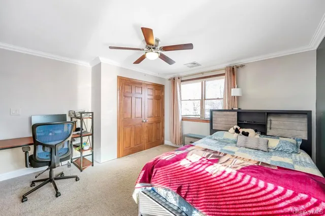 a bedroom with a bed a desk and chair with window