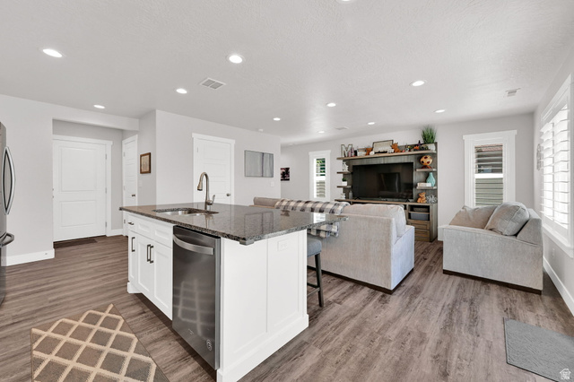 2777 West 4175th Street South, Unit 232 Roy, UT 84067 - Photo 9 of 27 Open-concept living space/kitchen featuring LVP flooring, recessed lighting, and white plantation shutters