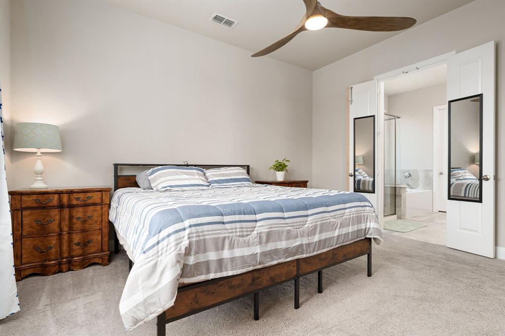 1320 Rosebush Road Aubrey, TX 76227 - Photo 18 of 33 a bedroom with a bed and chandelier