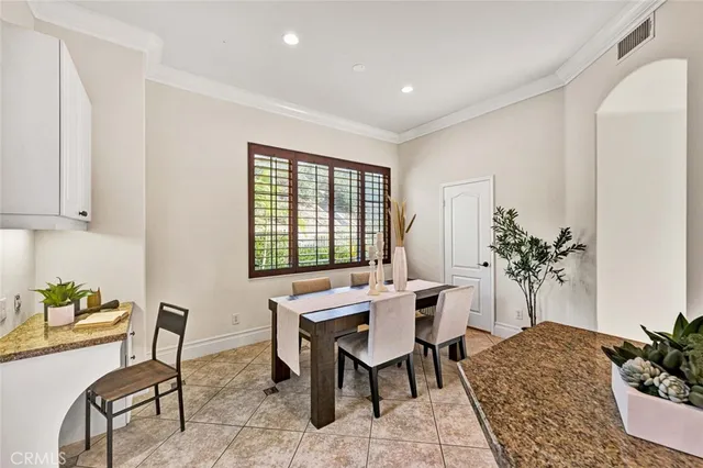 a dining room with furniture potted plants and wooden floor