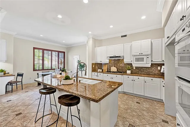 a large kitchen with granite countertop lots of counter top space and stainless steel appliances