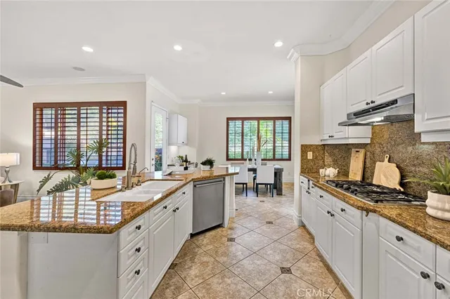 a large kitchen with stainless steel appliances granite countertop a sink and cabinets