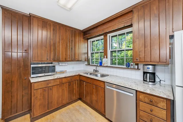 a kitchen with a sink window and cabinets