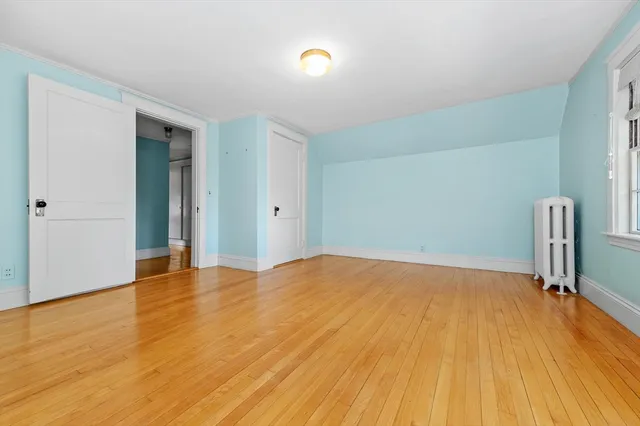 a view of empty room with wooden floor