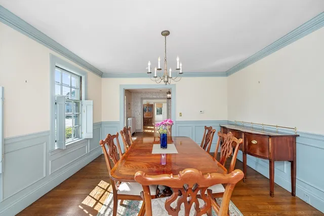 a view of a dining room with furniture a chandelier and wooden floor