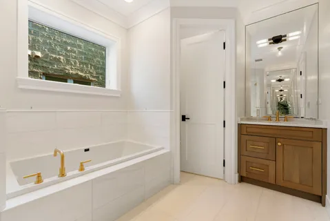 a bathroom with a tub sink and mirror