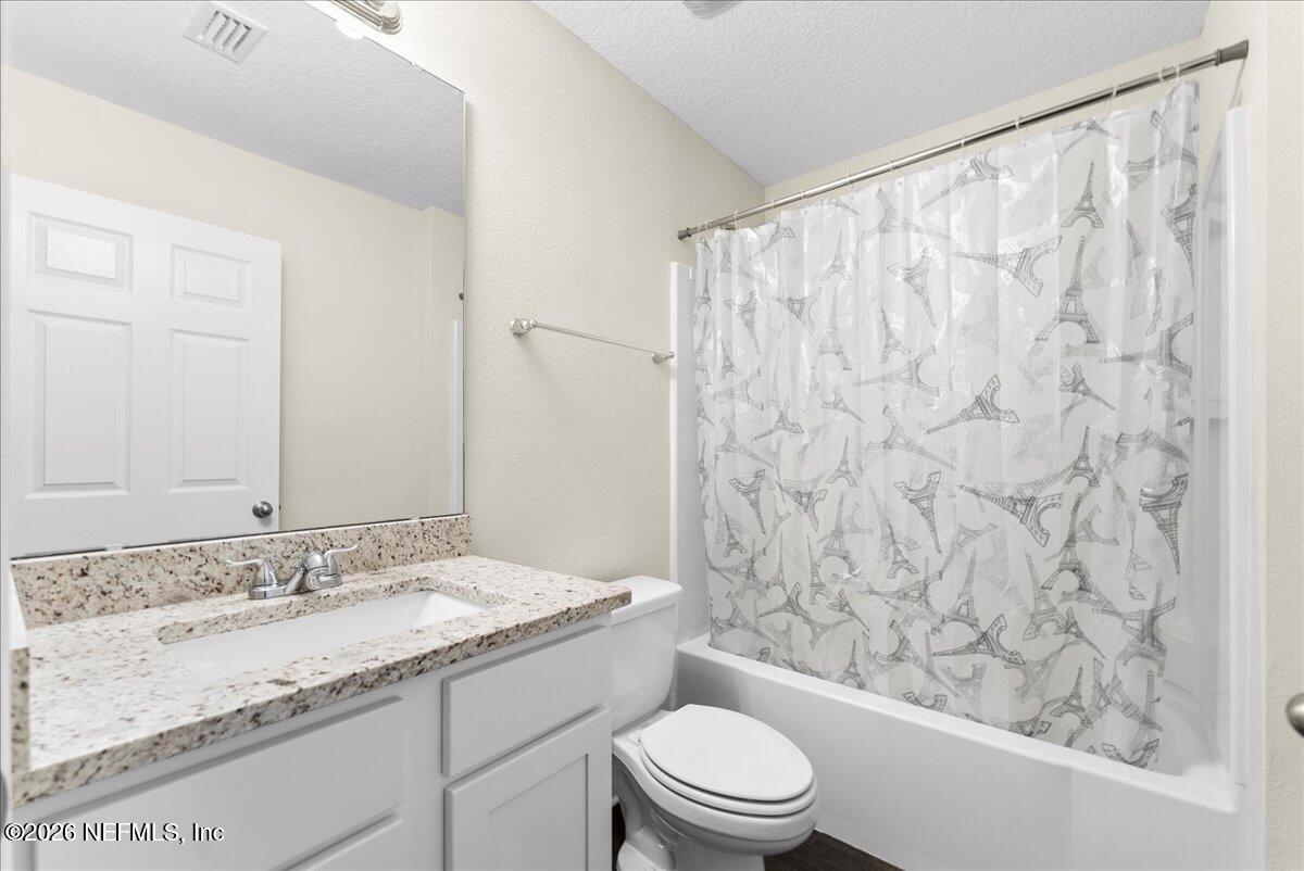 2383 Daisy Street Middleburg, FL 32068 - Photo 14 of 33 a bathroom with a granite countertop sink toilet and shower