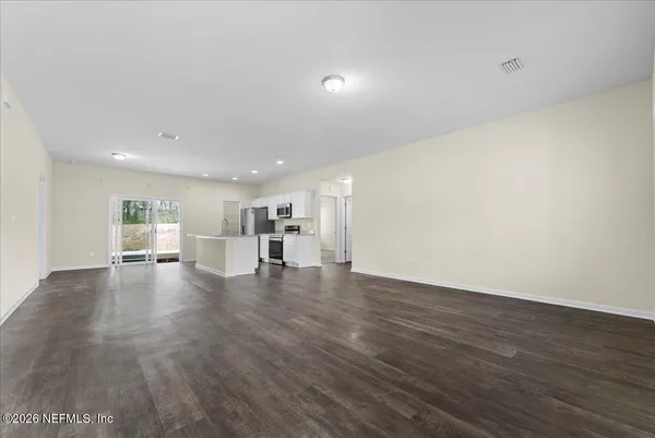 an empty room with wooden floor and window