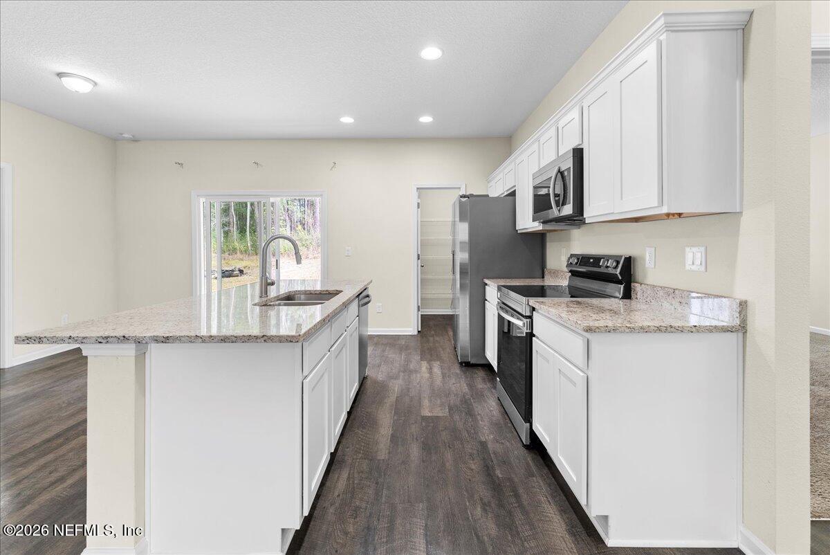 2383 Daisy Street Middleburg, FL 32068 - Photo 7 of 33 a kitchen with stainless steel appliances a sink stove and cabinets