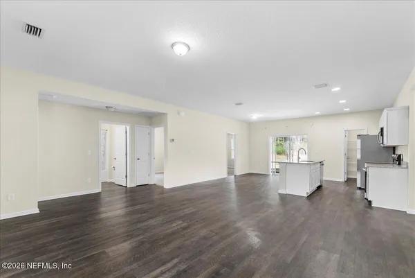 a kitchen with stainless steel appliances granite countertop a refrigerator a stove and a sink