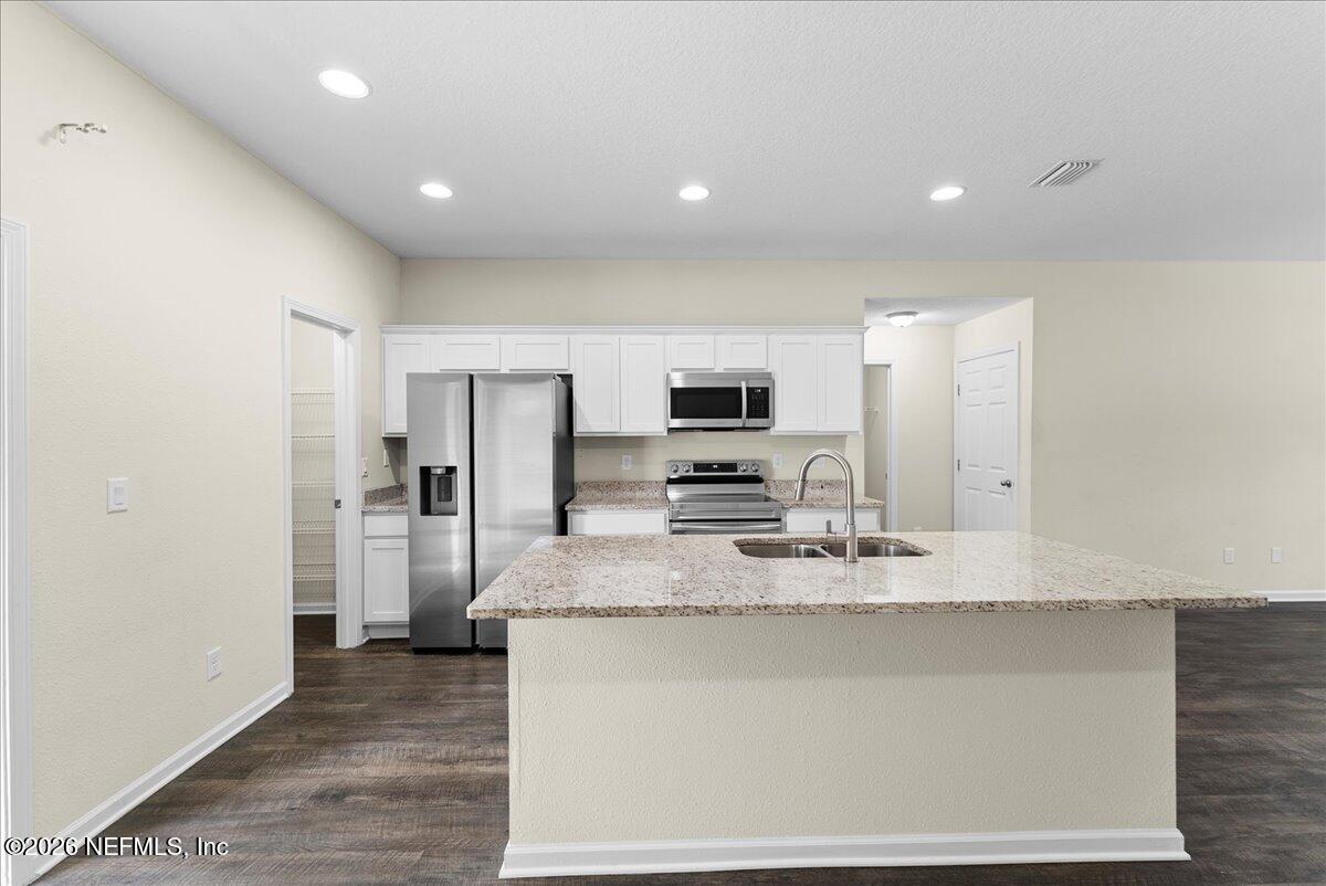 2383 Daisy Street Middleburg, FL 32068 - Photo 10 of 33 a large kitchen with stainless steel appliances granite countertop a granite counter tops and white cabinets