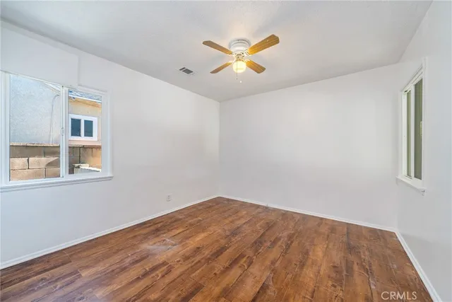 a view of a bedroom with wooden floor