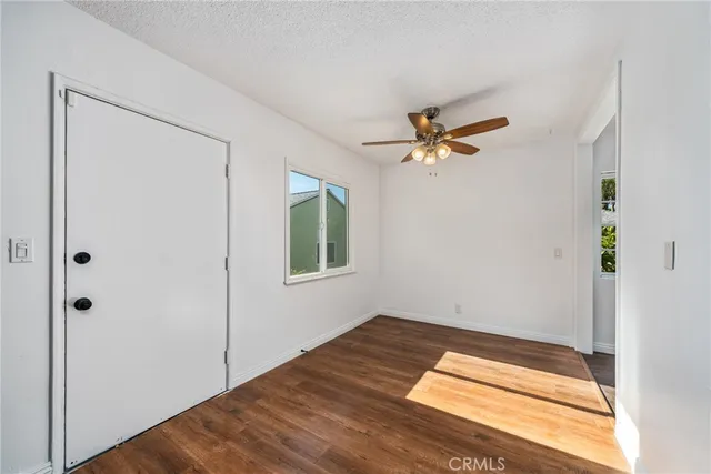 a view of a big room with wooden floor and a chandelier fan