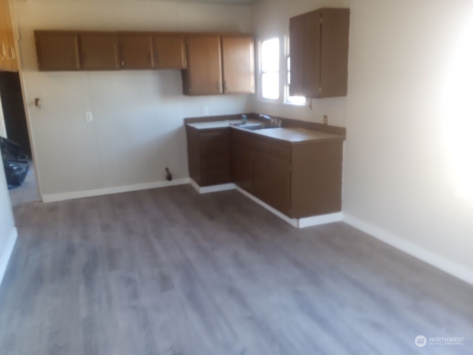 301 West 3rd Street Aberdeen, WA 98520 - Photo 15 of 15 a kitchen with granite countertop a sink and a stove with wooden floor