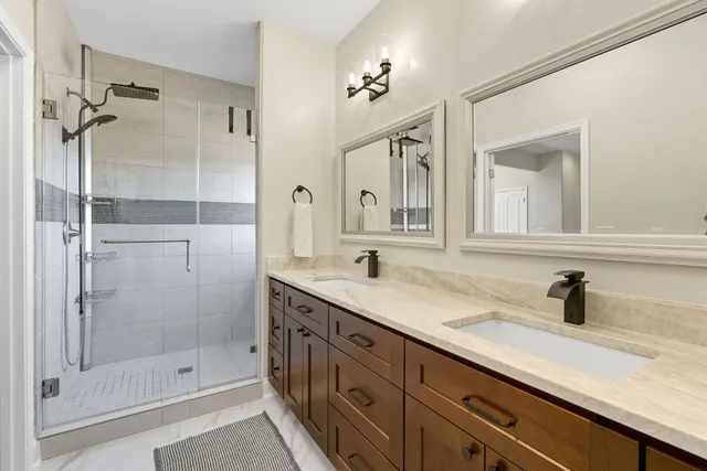 a bathroom with a granite countertop shower and a sink