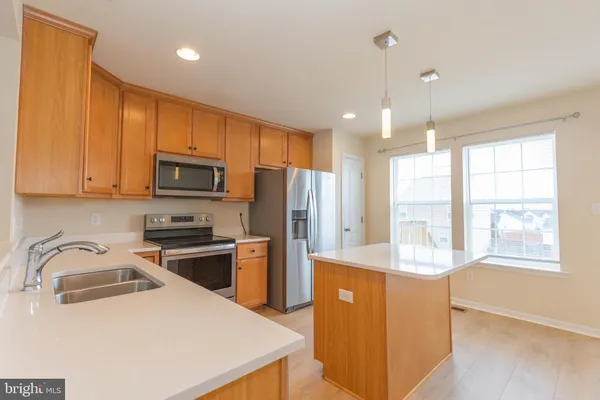 a kitchen with a sink a microwave a refrigerator and cabinets